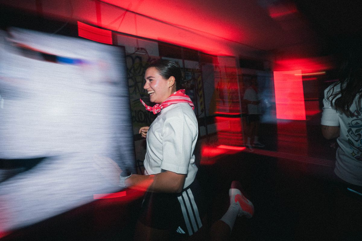 A runner smiling inside the red-lit Hyperground venue