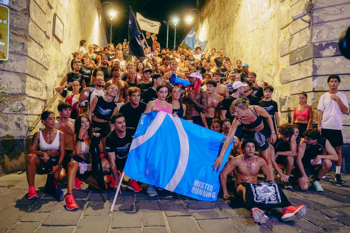 The LACE crew on the Scarlatti steps in Vomero at night, holding Saucony and Mister Running flags